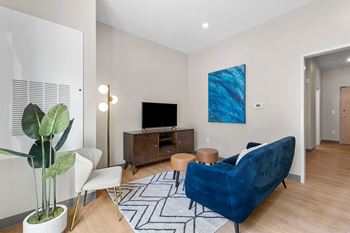 a living room with a blue couch and a tv on a wooden stand